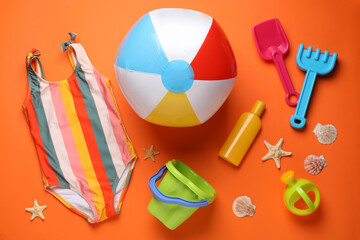 Flat lay composition with colorful beach ball and sand toys on orange background © New Africa
