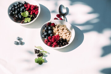 Oatmeal with raspberries and blueberries in a white plate .Breakfast