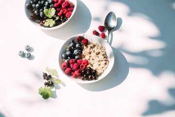 Oatmeal with raspberries and blueberries in a white plate .Breakfast