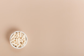 Organic natural dietary supplements, vitamins and minerals on brown background in rustic composition. Vitamins and medications for health support. Organic health care products. Nutritional supplements