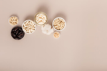 Organic natural dietary supplements, vitamins and minerals on brown background in rustic composition. Vitamins and medications for health support. Organic health care products. Nutritional supplements