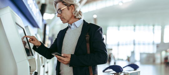 Businessman using self-service airport check-in