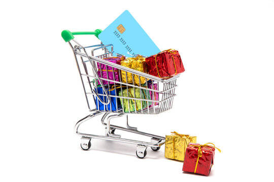  Giftboxes kept beside a shoppingcart containing colorful gifts and credit card.
