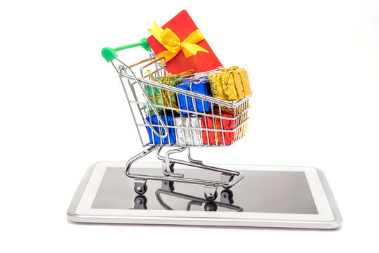 A shoppingcart consisting giftboxes and giftcard kept on mobilephone.