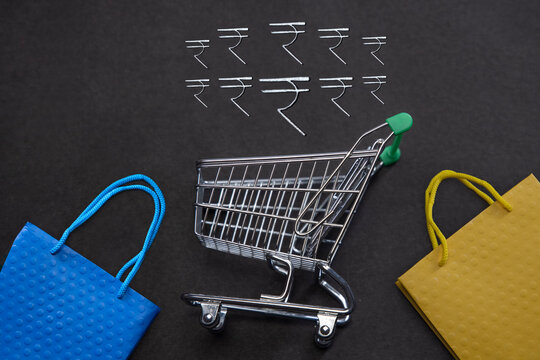 Indian ruppee sign,Shoppingcart and Shoppingbags together in a frame.