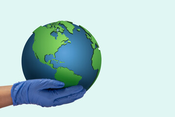 Human hand wearing gloves holding Earth against plain background.