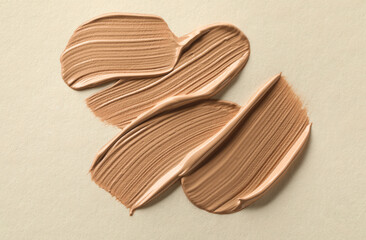 Sample of liquid skin foundation on beige background, top view