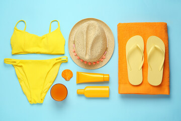 Flat lay composition with different beach objects on light blue background