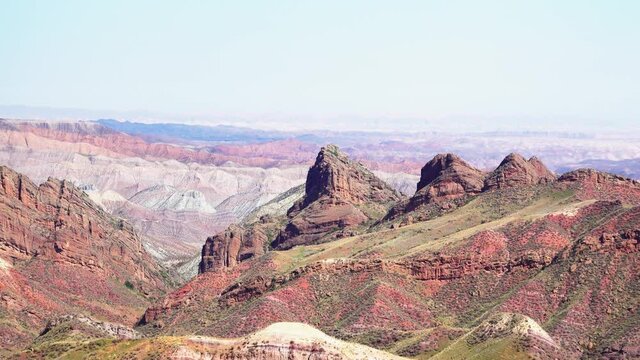 Hills formed by erosion of colored rocks with reddish-yellow and orange stripes. Baili Danxia landforms are majestic, strangely shaped and colorful. Xinjiang, China. 2018