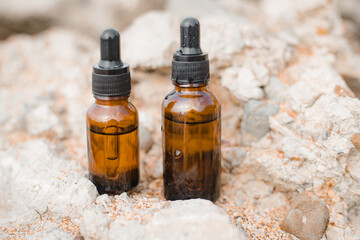 A bottle of cosmetic oil on a background of stones . Cosmetic oil. Cosmetology. Stones. An oil based on algae.