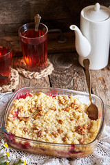 Peach and plum streusel pie. Walnuts, tea, chamomile, side view, wooden background, rustic.