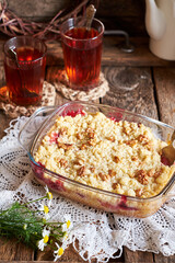 Peach and plum streusel pie. Walnuts, tea, chamomile, side view, wooden background, rustic.
