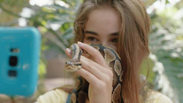 nature girl holding snake taking selfie photo using smartphone enjoying zoo excursion sharing creepy reptile on social media 4k