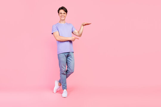 Full length body size view of attractive cheerful guy showing copy blank space ad size isolated over pink pastel color background