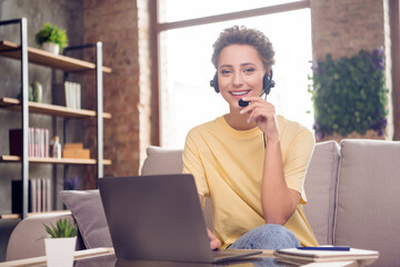 Photo of pretty reliable operator lady hold laptop work wear headset yellow t-shirt in modern house indoors