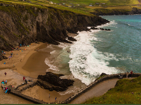 Wild Atlantic Way Dunmore Head beach with wild and windy waves for great fun and surfing. Family fun time secluded with beautiful coloured waters and white sand beach. Near Dunquin Head, Kerry Ireland