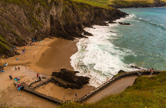 Wild Atlantic Way Dunmore Head beach with wild and windy waves for great fun and surfing. Family fun time secluded with beautiful coloured waters and white sand beach. Near Dunquin Head, Kerry Ireland