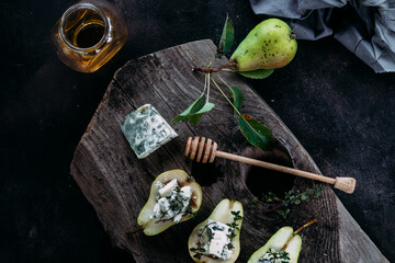 Pear with dor blue cheese and honey on a wooden background