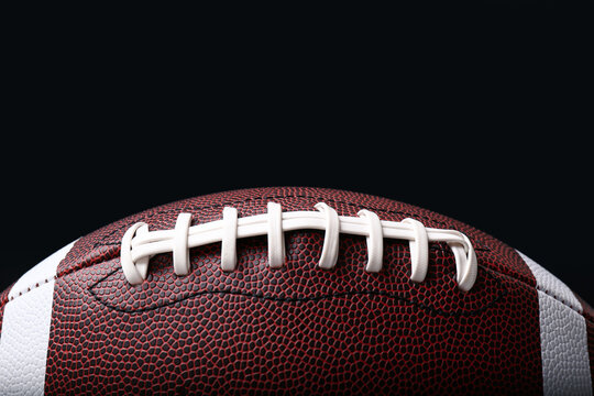 Leather American football ball on black background, closeup