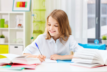 education and school concept - happy smiling student girl with books learning over home room background
