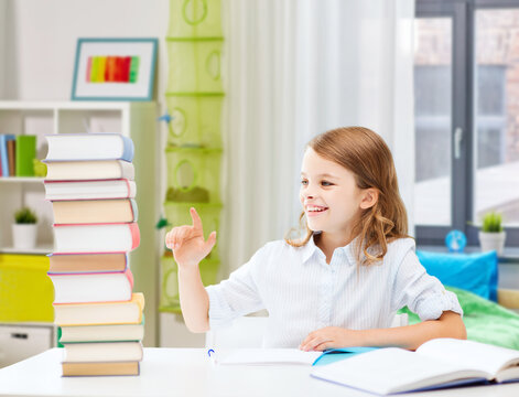 education and school concept - happy smiling student girl reading book over home background