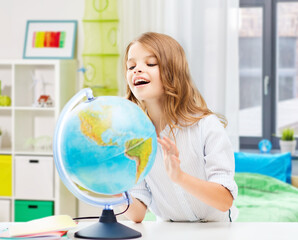 education, geography and school concept - smiling student girl with globe over home room background