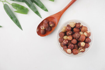 hazelnuts in a container on white background,