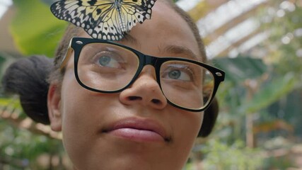 happy girl smiling with butterfly on face fluttering wings having fun with wildlife in nature conservation zoo teenage biology nerd 4k