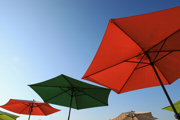 Colorful beach umbrellas against blue sky on sunny day