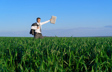 businessman works in a green field, freelance and business concept, green grass and blue sky as background