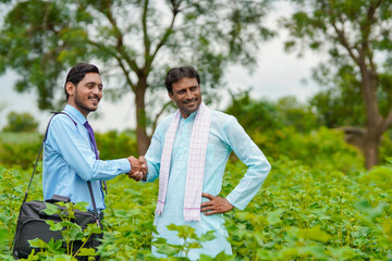 Indian farmer Discussing with agronomist at Farm shake hand at agriculture field