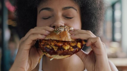 beautiful woman with afro eating burger in restaurant enjoying delicious juicy hamburger mouth watering meal african american female having lunch 4k
