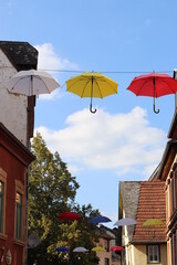 Bunte Regenschirme hängen über der Straße.