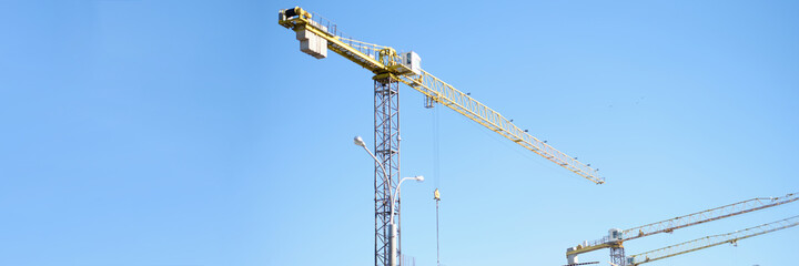 Construction cranes are standing near building houses