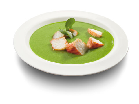 Crema de guisantes con lomo sobre fondo blanco. Creamed peas with tenderloin on white background.
