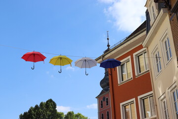 Bunte Regenschirme hängen über der Straße.