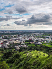 Fototapeta premium View of city from the beautiful mountain. Blue sky and green meadow in sunset time.