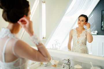 a beautiful young woman in a silk robe by the mirror in the bathroom. 