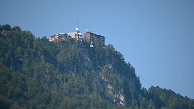 Famous Vogel lift above lake Bohinj, Slovenia. Telephoto perspective of cable way ascending. Cable car transporting people. Static shot, real time