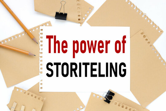 THE POWER OF STORYTELLING, business concept, text on white notepad paper. on a white photo with torn paper