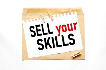 Sell Your Skills, text on paper on craft envelope on white background