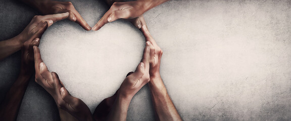 Different people unite for a common purpose as diverse person hands join together and create heart shape, isolated on grey wall background with copy space. Race diversity and love an teamwork concept