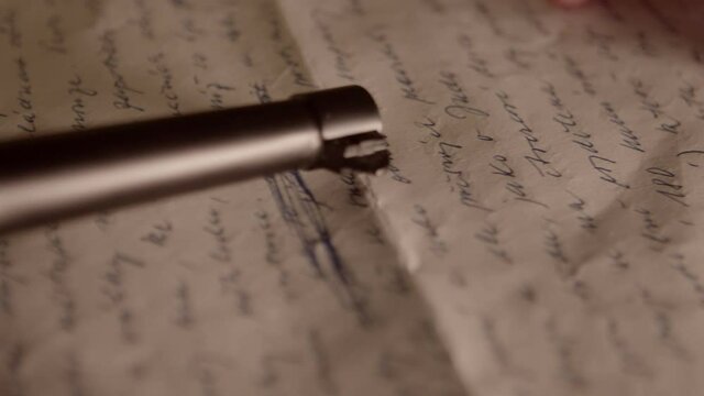 Goodbye letter after committing suicide, gun in hand closeup slider shot