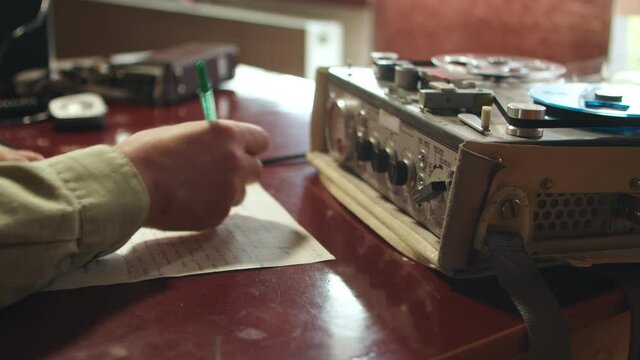 Making notes of crime evidence from old tape recorder, closeup shot