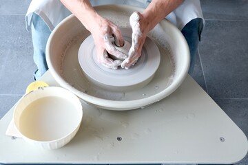 Handcrafted on a potter's wheel,Hands make clay from various items for home and sale in the store and at the exhibition, ceramic items are made in hand, the clay billet becomes a ceramic dish