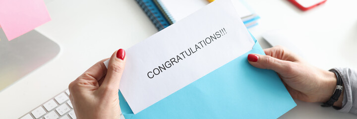 Female hands holding envelope with congratulations closeup