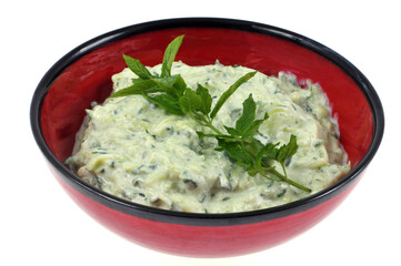 Ramequin de tzatziki maison avec des feuilles de menthe en gros plan sur fond blanc