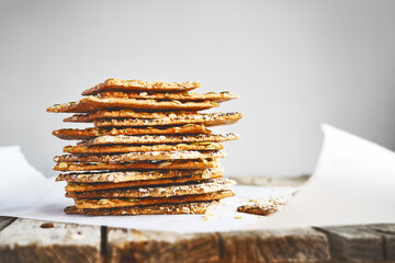 Crunchy crispbread on recycled paper on wooden table. Whole Grain crisp bread with pumpkin,...