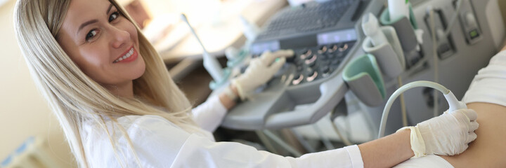 Woman doctor doing ultrasound examination of kidneys to female patient in clinic