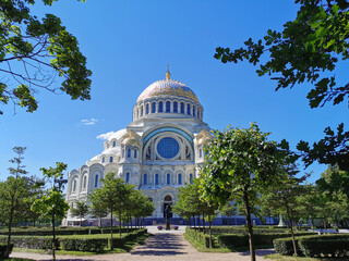 View of the square and the St. Nicholas Cathedral among the trees, built in 1903, on a summer day in Kronstadt.